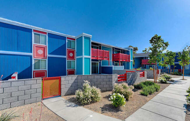 A modern building with blue and red panels and a red door.