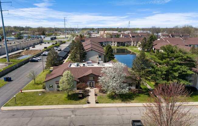 an aerial view of a neighborhood with a pond and houses