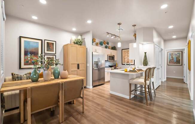 A kitchen with a dining table and chairs.