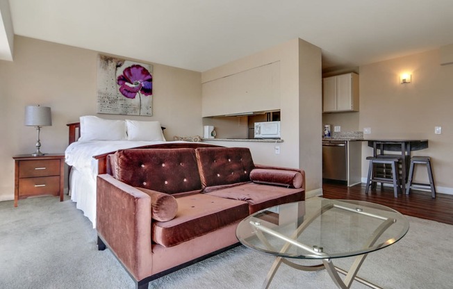 sleeping and living area with carpet floorings. Dining and kitchen with wood style floors