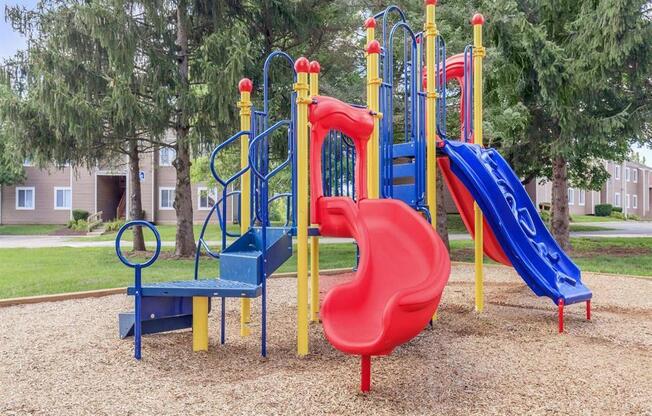 a playground with a blue slide and red and blue slides