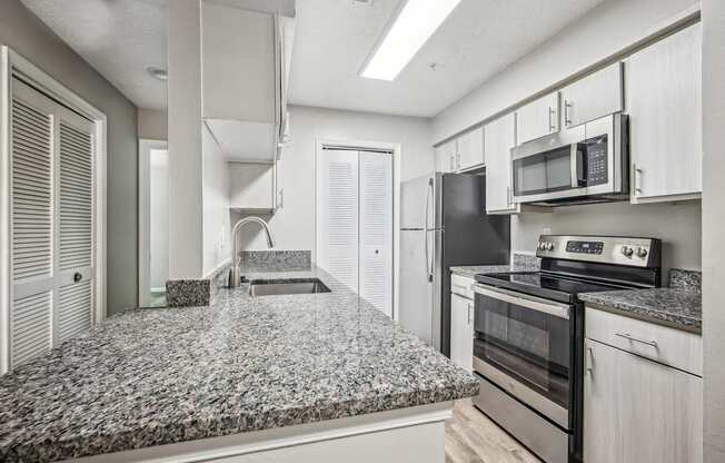 A kitchen with granite countertops and stainless steel appliances.