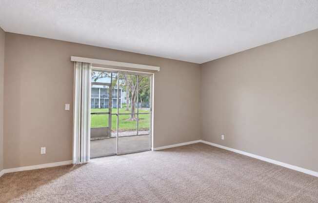 Unfurnished carpeted bedroom with sliding doors to a screened patio at Waterchase Apartments in Largo, FL.