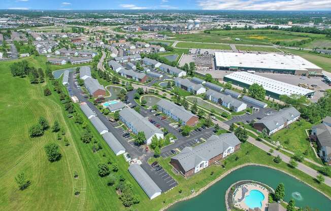 an aerial view of a city with houses and a lake