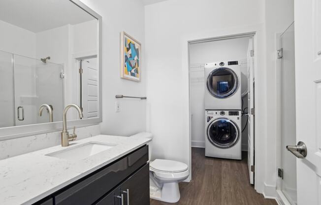 a bathroom with a toilet sink and a washing machine    and a laundry at Link Apartments® Mint Street, Charlotte, North Carolina