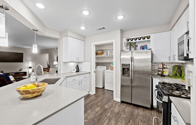 a kitchen with white cabinets and stainless steel appliances