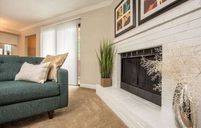 a living room with a fireplace and a green couch at Lodge of Overland Park Apartments, Kansas, 66212