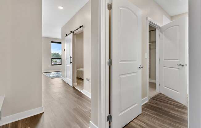 a bedroom with white doors and hardwood floors