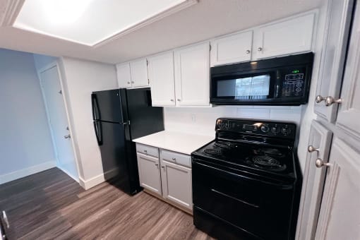 a kitchen with black appliances and white cabinets