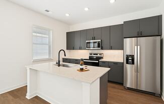 A modern kitchen with a white island and stainless steel appliances.
