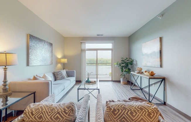 a living room with a sliding glass door leading to a balcony