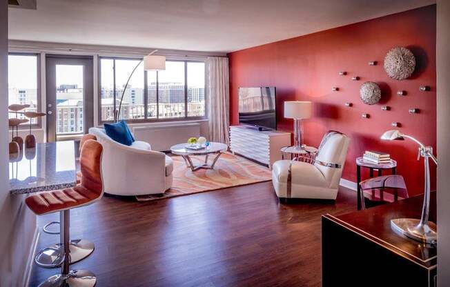 A living room with a red wall and a white chair.