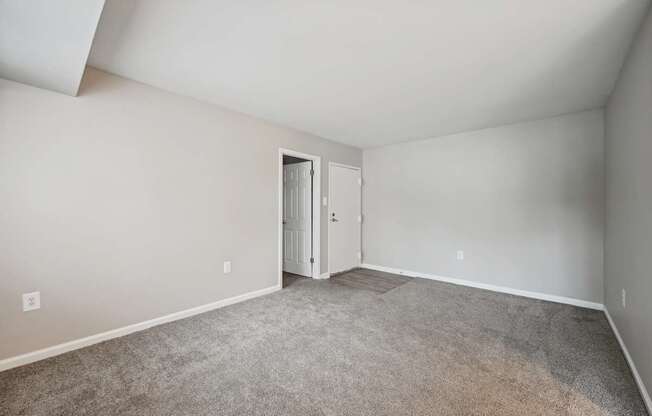 an empty room with carpet and a door to a closet at ReNew Odenton