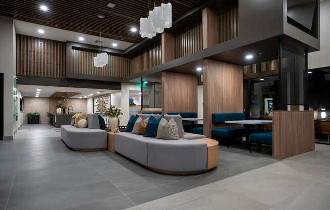 A modern living room with a grey sofa and wooden accents.