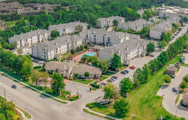 A large apartment complex with a pool in the middle.