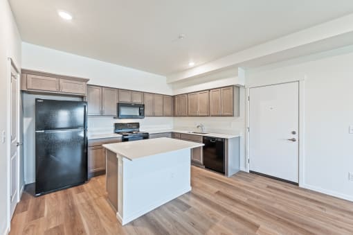 a kitchen with a white counter top and a black refrigerator at Gateway Apartments, East Wenatchee , WA 98802