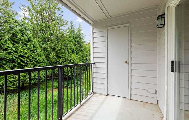 A white door is on the right side of a porch.