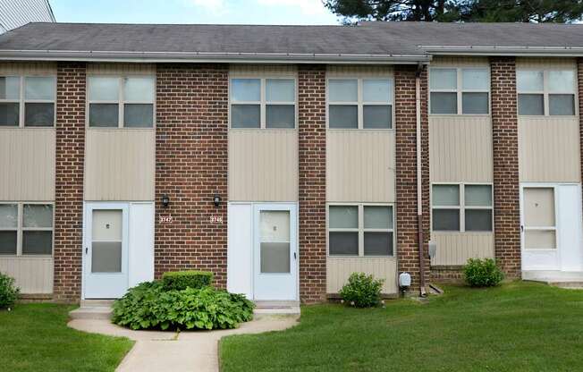 A brick building with white doors and windows.