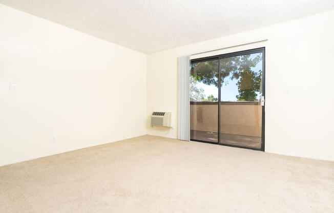 an empty living room with a sliding glass door