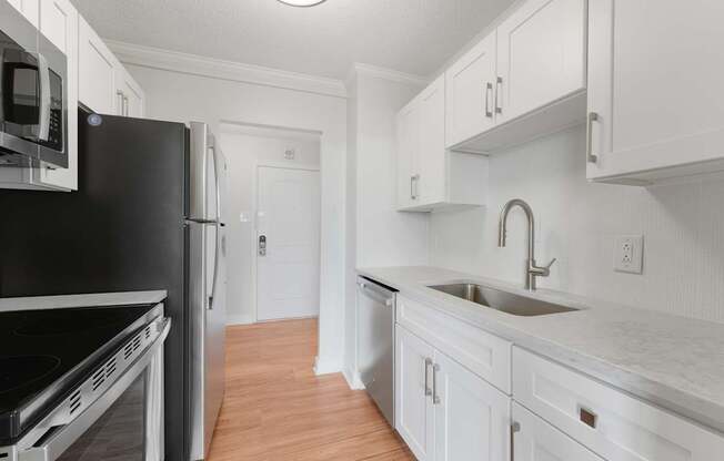 A kitchen with white cabinets and a black fridge at Riverside Apartments, Alexandria, Virginia