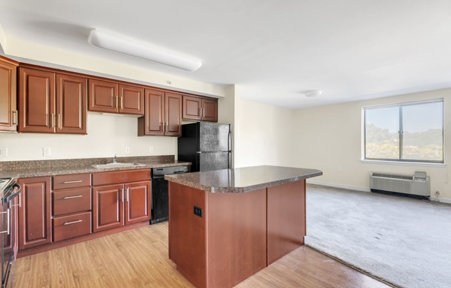 an empty kitchen with wooden cabinets and a counter top