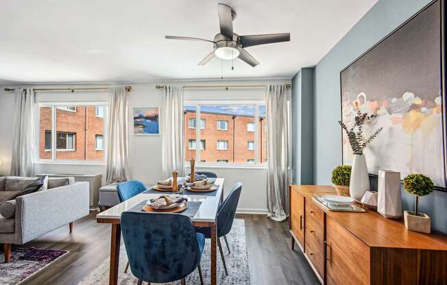 A dining room with a table set for four and a couch.