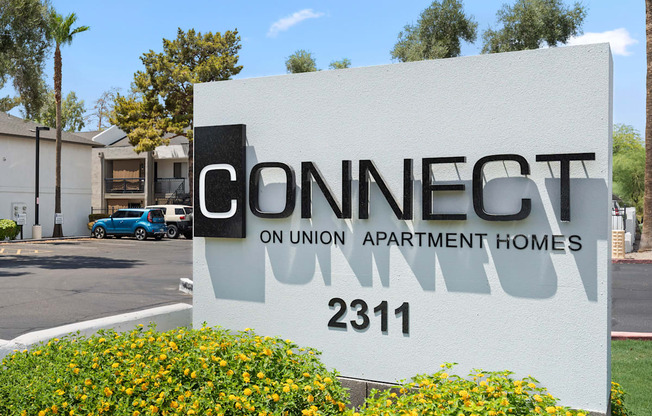 A white sign with black lettering that says Connect Union Apartment Homes 2311.