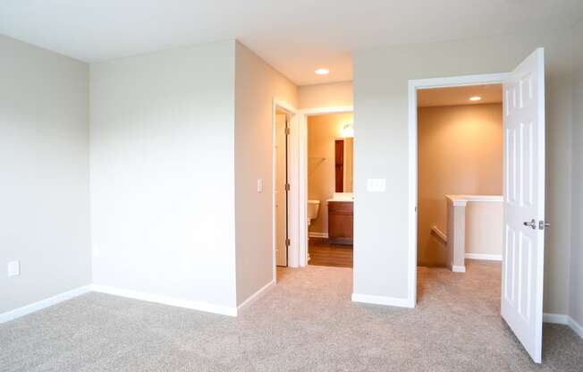 a bedroom with a door open to a bathroom and a closet