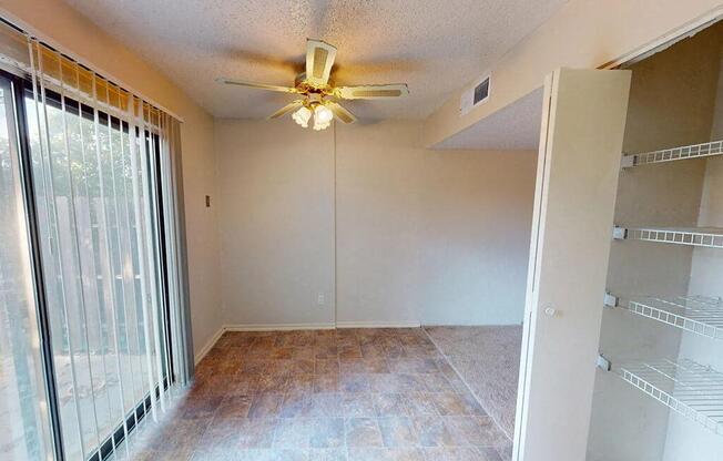 a living room with a ceiling fan and a sliding glass door