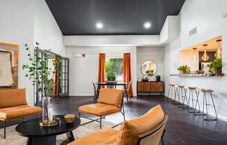 A living room with orange chairs and a black table.