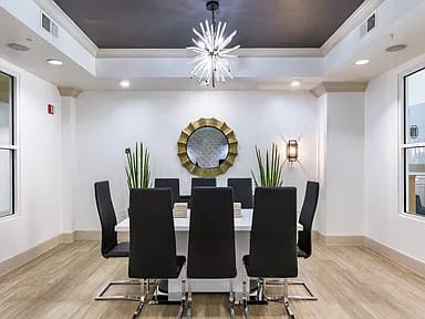 A conference room with a round mirror and a chandelier.