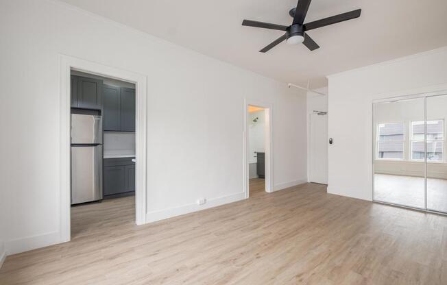 A spacious room with a ceiling fan and wooden flooring at Westmore Manor Apartments, Los Angeles