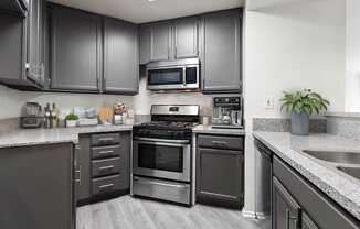 Stone tiled kitchen with stainless steel oven, microwave, and fixtures.