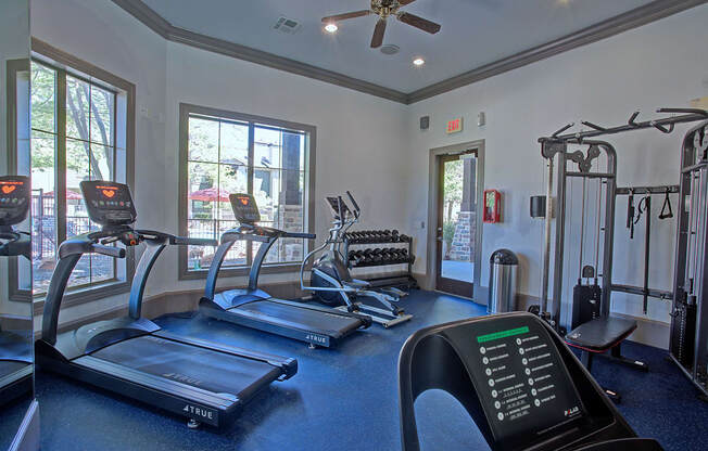 A gym with treadmills, elliptical machines, and other exercise equipment.