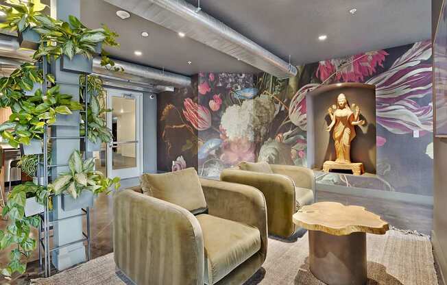 A living room with a large mural and two chairs.