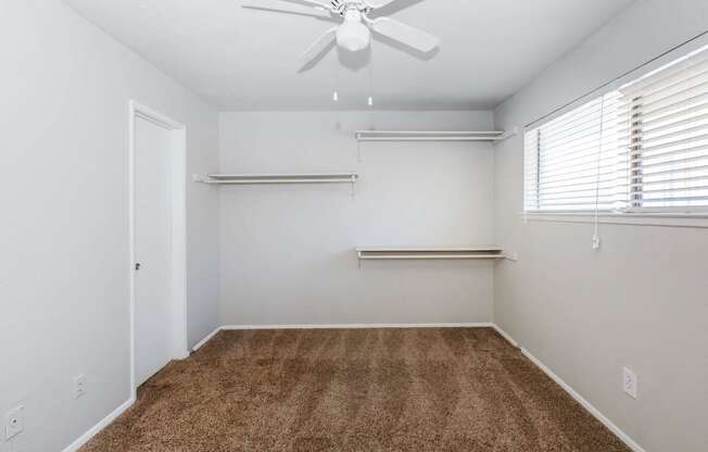a room with a carpet and a ceiling fan