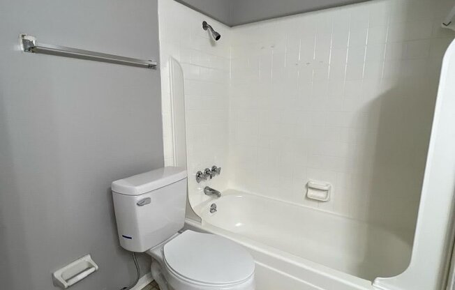 an empty bathroom with a toilet and a tub