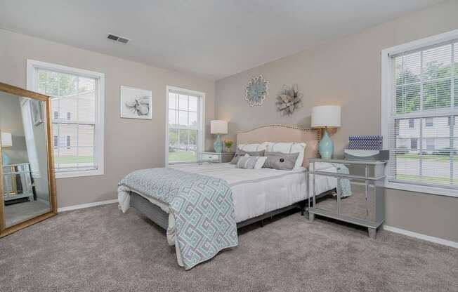 A bedroom with a large bed and a mirror on the wall.