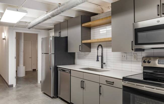 a kitchen with stainless steel appliances and white counter tops at Highland Mill Lofts, North Carolina