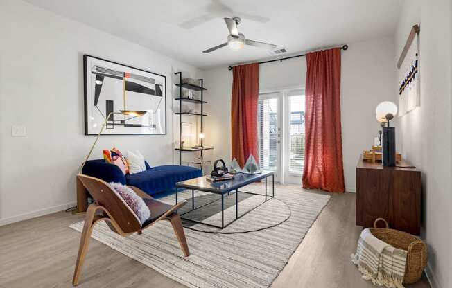 A living room with a blue sofa and a wooden chair. at Bridge at Tech Crossing, Austin, Texas