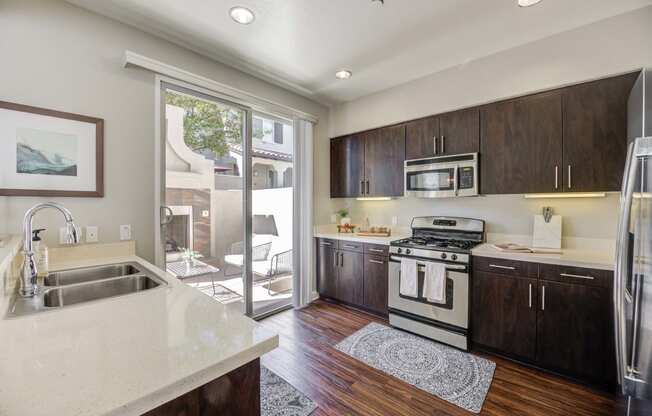 a kitchen with a sink and stove and a door to a patio