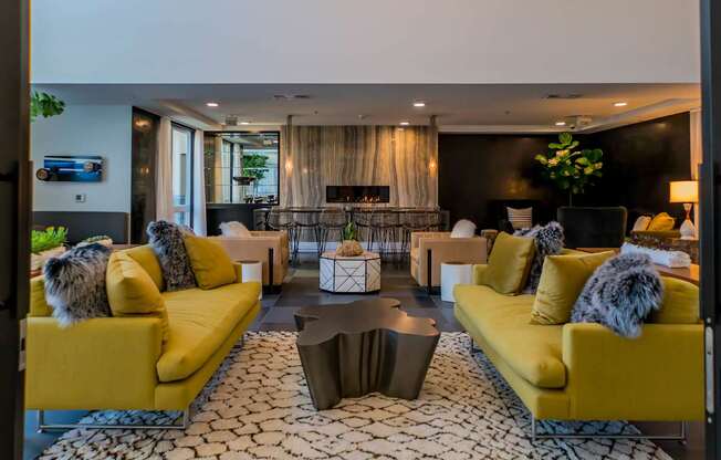 A living room with yellow couches and a patterned rug.