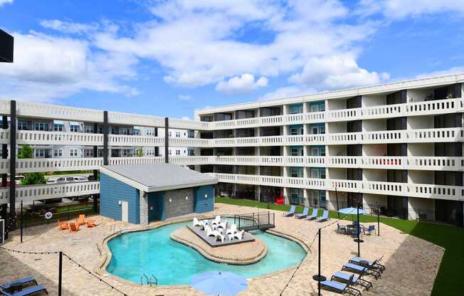 A large apartment complex with a pool and hot tub.