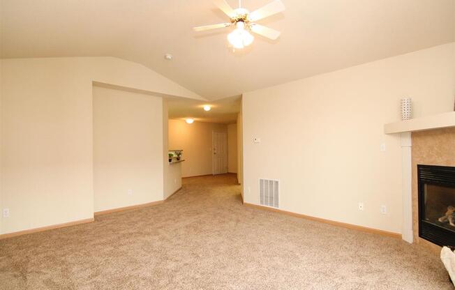 Living room with fire place and ceiling fan at Northbrook Apartments in Lincoln NE
