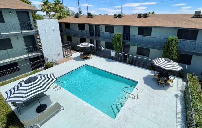 an aerial view of a swimming pool in front of a building