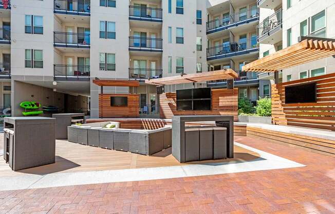A modern outdoor seating area with wooden and concrete furniture.