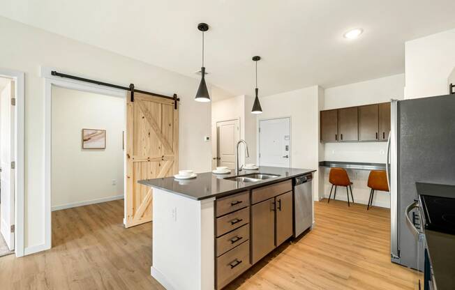 a kitchen with a large island and a sliding barn door at The Standard on 32nd, West Fargo