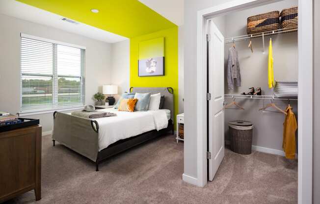 a bedroom with a green accent wall and gray carpet  at Abberly Noda Vista Apartment Homes, Charlotte, NC, 28206