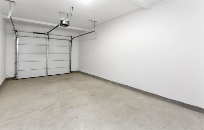 an empty room with a white wall and a garage door