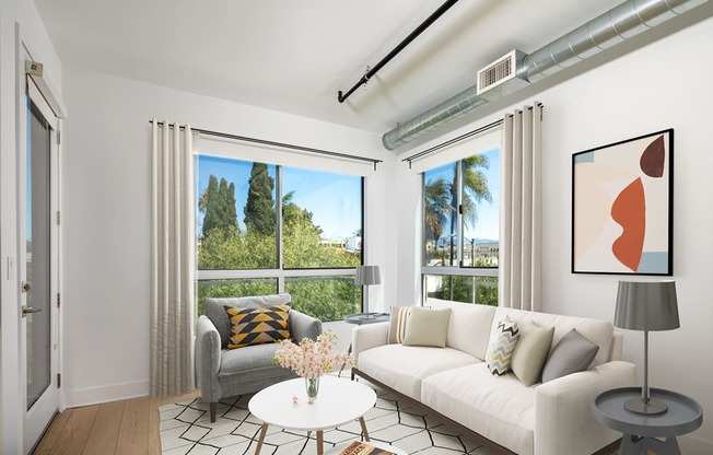 a living room with a white couch and a table with a vase of flowers